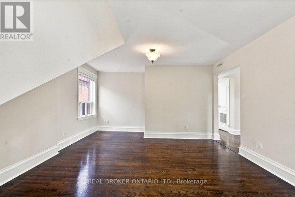 Light beige room with dark hardwood floors and two windows. - 3 - 12 Foxbar Road, Toronto