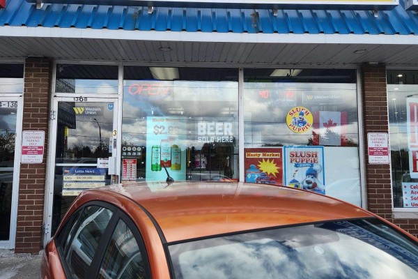 View of Hasty Market entrance highlighting 'BEER SOLD HERE' sign and product advertisements. - 3 - 136 Guelph Street, Halton Hills