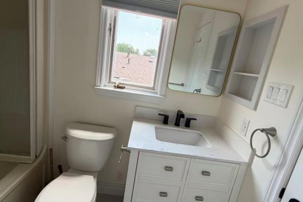 Bathroom vanity with a white countertop and sink, black faucet, and a mirror above. - 3 - 19 Dunsfold Drive, Toronto