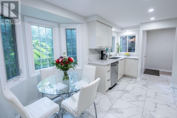 Dining area in a kitchen with a bay window and view of greenery. - 3 - 228 Kingswood Drive, Kitchener