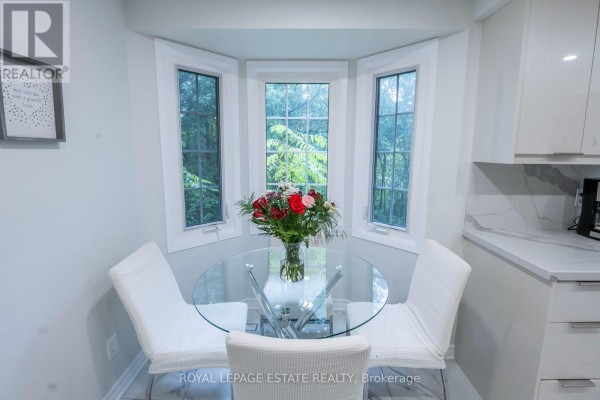 Close-up of a glass dining table and chairs in front of a bay window. - 3 - 228 Kingswood Drive, Kitchener