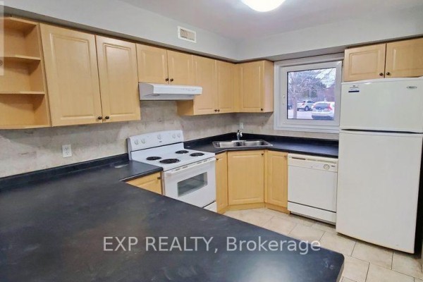 Kitchen with light wood cabinets, white appliances, black countertops, and tile floor. - 246 Lakeshore Road, St  Catharines