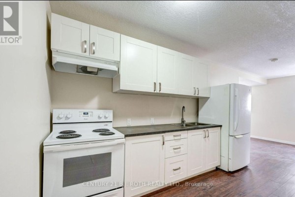 Kitchenette with white cabinets, white stove, dark countertop, sink, and white refrigerator. - 3 - 303 Moffat Street, Orillia