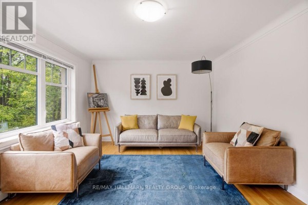 Living room with light hardwood floors, white walls, and a large window. - 3 - 34 Lavergne Street, Ottawa