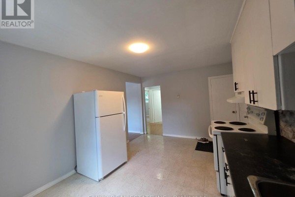 Kitchen area with a white refrigerator, white cabinets, and a doorway. - 3 - 362 Grey Street, Brantford