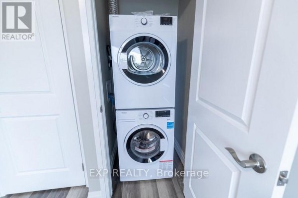 White stacked front-loading washing machine and dryer in a narrow closet. - 3 - 3815 Portage Road, Niagara Falls