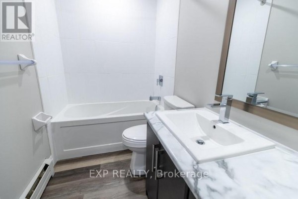Small bathroom with white tub, toilet, vanity, and marble-look countertop. - 3 - 3815 Portage Road, Niagara Falls
