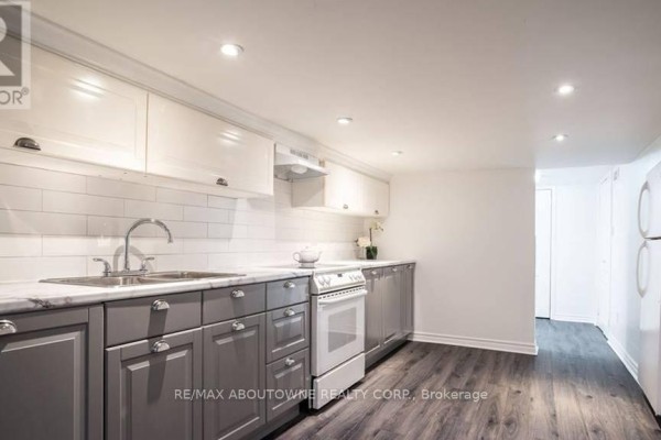 Kitchen with grey lower cabinets, white subway tile backsplash, and stainless steel sink. - 3 - 43 Crooks Street, Hamilton