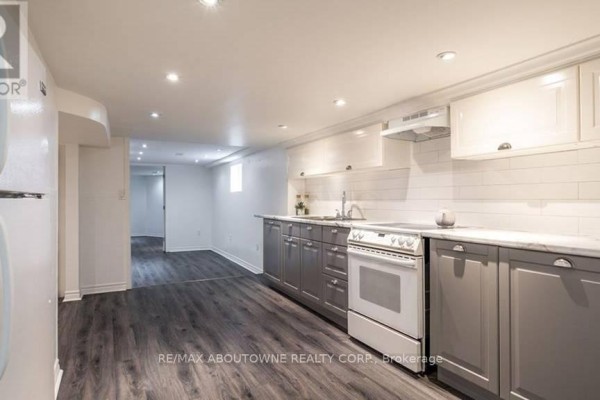 Kitchen with white upper cabinets, grey lower cabinets, and white appliances. - 3 - 43 Crooks Street, Hamilton