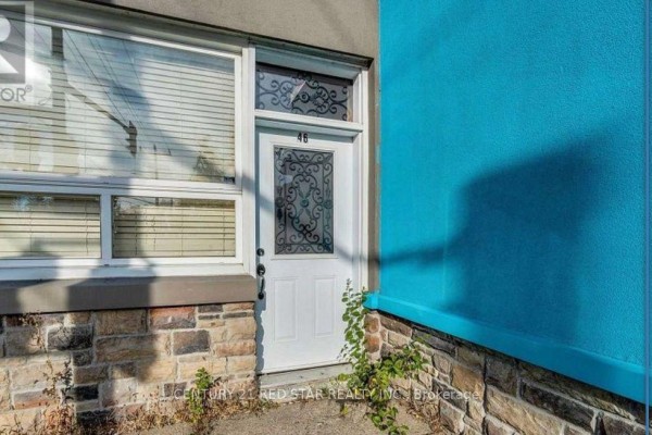 Close-up of the building's white front door with decorative glass, address number 46, and stone foundation. - 3 - 44 Centre Street N, Brampton