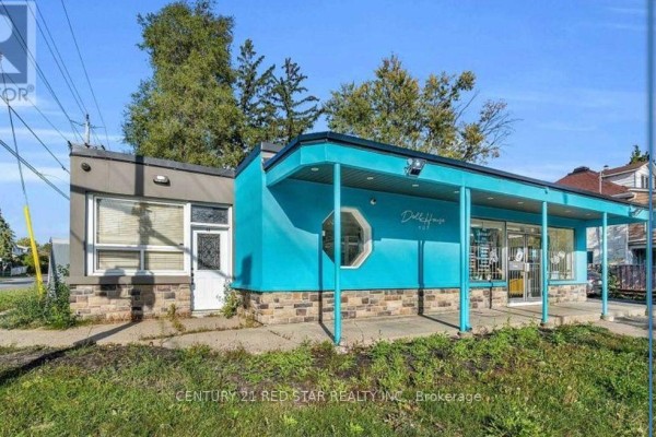 Exterior view of a single-story commercial building featuring a bright turquoise entrance canopy and stone accents. - 3 - 44 Centre Street N, Brampton