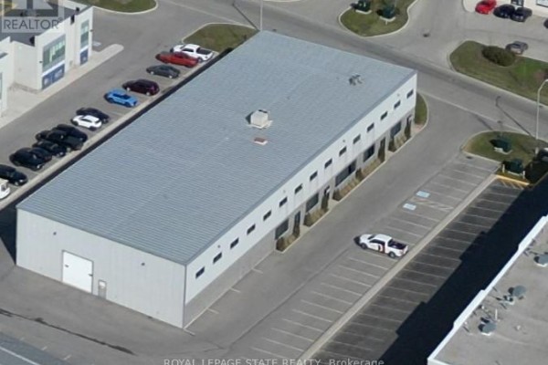 Aerial view of a long, rectangular commercial building with a metal roof and parking lot. - 3 - 44 Ditton Drive, Hamilton