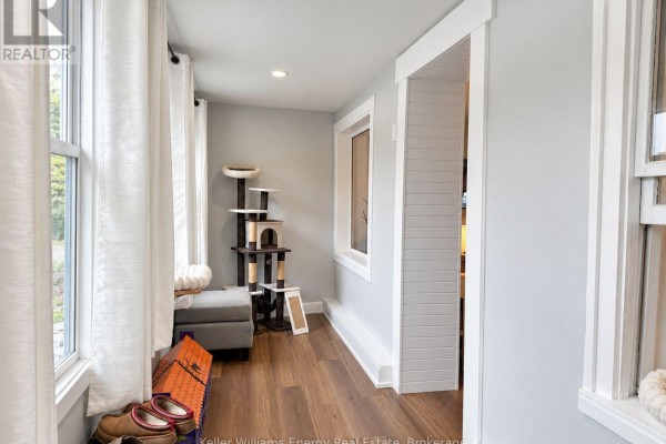 Bright hallway with white curtains, a cat tree, and wooden flooring. - 3 - 5 Crandall Street, Kawartha Lakes