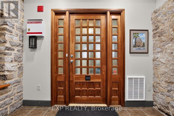 Interior view of an apartment entrance door with glass panes and numbering 103. - 3 - 7 Mill Street, Mississippi Mills