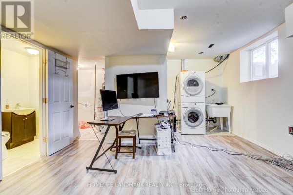 Dining area with a table and chairs next to a stainless steel refrigerator and a doorway. - 3 - 736 Kingston Road, Toronto