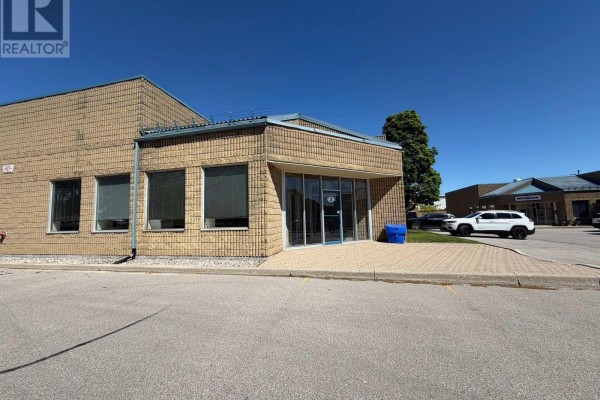 Empty commercial office space with large window and light grey wood-look flooring. - 3 - 900 Mckay Road, Pickering