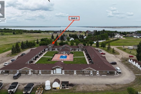 Aerial view of the U-shaped complex with a large body of water in the distance, Unit 3 highlighted. - 3 1250 Aaro Avenue, Elbow