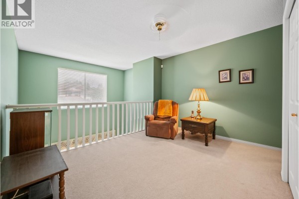 Loft area with green walls, a railing, a recliner chair, and a side table. - 3 1370 Riverwood Gate, Port Coquitlam
