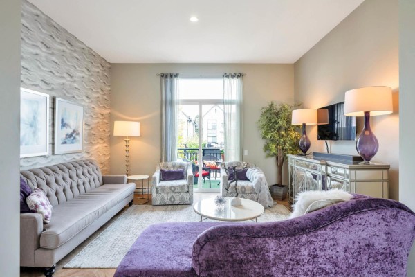 Living room with grey tufted sofa, purple chaise, patterned armchairs, and textured accent wall. - 3 17555 57a Avenue, Surrey