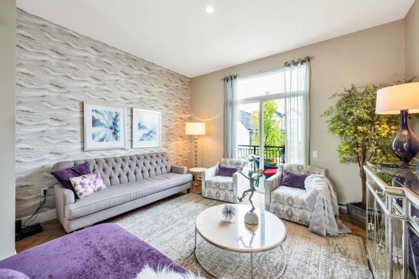 Living room with tufted sofa, patterned chairs, and a glass door leading to an outdoor balcony. - 3 17555 57a Avenue, Surrey