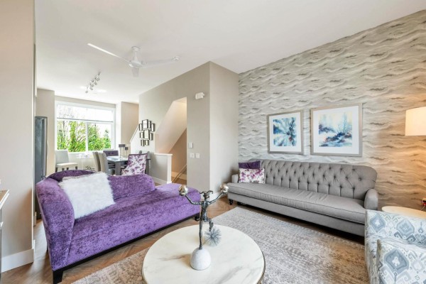 Living room with two sofas, patterned armchairs, a coffee table, and a view of the dining area. - 3 17555 57a Avenue, Surrey