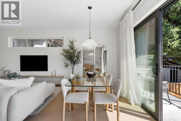 Dining area with glass table, chairs, a television, and sliding glass doors to the balcony. - 3 2124 E 8 Avenue, Vancouver