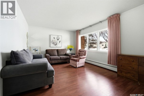 Living room with two couches, a chair, and large windows with natural light. - 3 4341 Rae Street, Regina