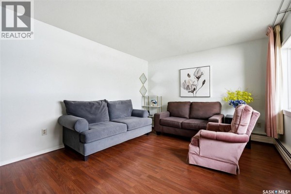 Another angle of the living room showcasing furniture and window view. - 3 4341 Rae Street, Regina