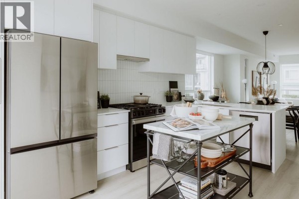 Kitchen with stainless steel refrigerator, gas range, and white countertops. - 3 4552 Cattail Way, Tsawwassen