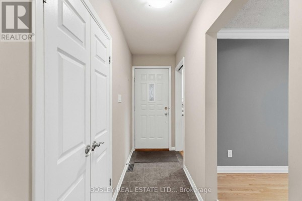 Foyer with white double doors, a white front door, and neutral walls. - 3 Brian Avenue, St  Catharines