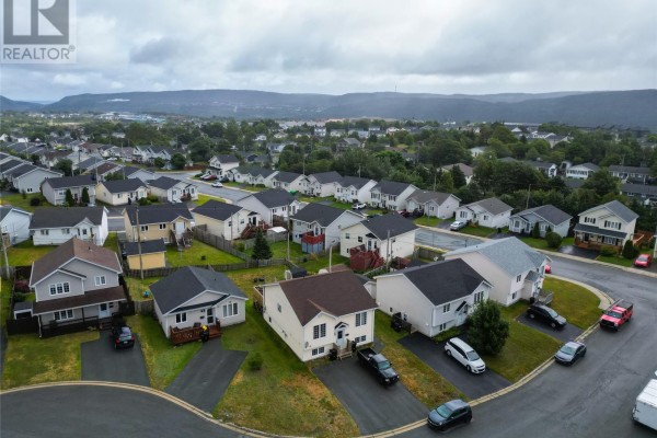 Aerial view of a neighborhood with houses and distant hills under a cloudy sky. - 3 Caprea Place, St  John S