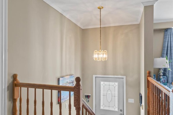 Interior view of a home entryway with a wooden staircase and a glass-paned door. - 3 Caprea Place, St  John S