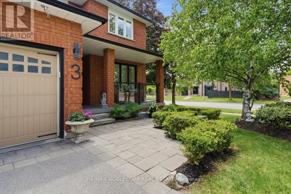 Close-up of the brick house entrance with a paved walkway, shrubs, and a large tree. - 3 Castlehill Road, Vaughan