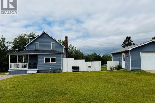 Side view of the blue house with a white fence and a detached garage to the right. - 3 Ch Manuel, Baie Sainte Anne