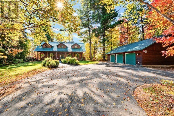 View of log home and detached three-car garage with green doors on a sunny autumn day. - 3 Dam Road, Brudenell, Lyndoch And Raglan