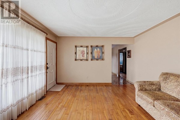 Living room with hardwood floors, a sofa, and large curtains. - 3 Dawson Ave, Sault Ste  Marie