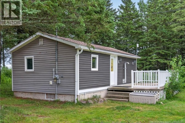 Rear exterior view of the grey house with white siding and a small window. - 3 Des Sapins Avenue, Sainte Marie De Kent