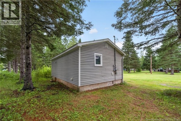 View of the white deck on the grey house with three chairs and propane tank. - 3 Des Sapins Avenue, Sainte Marie De Kent