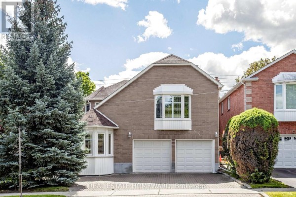 Side view of a brick house with a three-car garage and a bay window, surrounded by trees. - 3 Green Acres Road, Vaughan