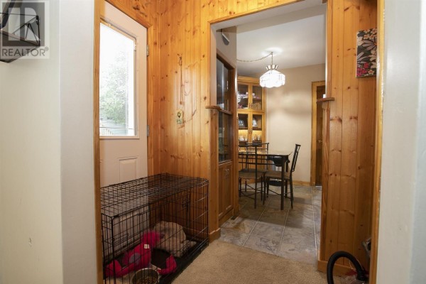 Hallway with dog crate, wood paneling, dining table, and china cabinet - 3 Henrietta Ave Sault Ste Marie