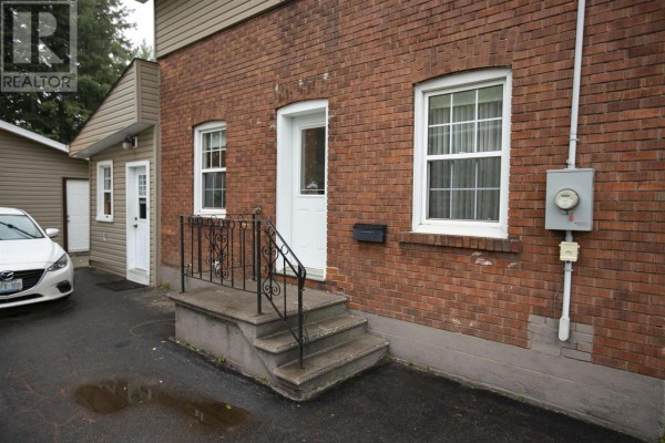 Close-up of the front entrance with brick exterior, concrete steps, and white doors. - 3 Henrietta Ave, Sault Ste  Marie