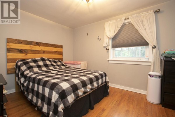 Bedroom with wooden headboard and plaid blanket - 3 Henrietta Ave Sault Ste Marie