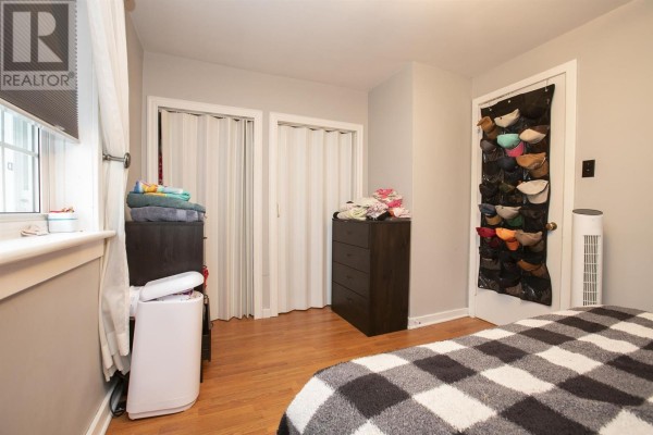 Bedroom with dressers, folding closet doors, hat organizer, and fan - 3 Henrietta Ave Sault Ste Marie