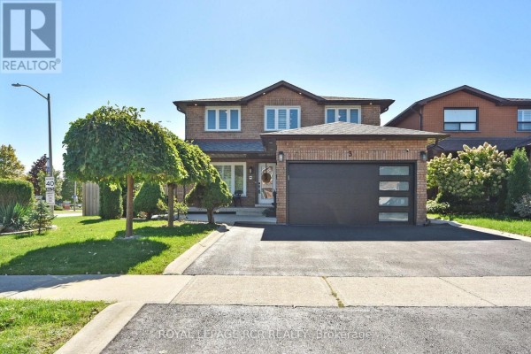 Close-up exterior view of the house's front garden with sculpted bushes, a statue, and trees. - 3 Jackman Crescent, Vaughan