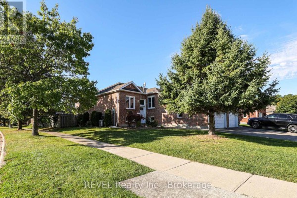 Side exterior view of a brick house with a lawn and walkway. - 3 Jackson Court W, Welland