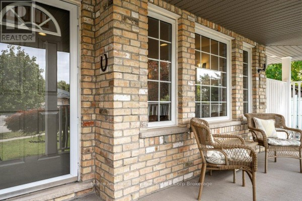 Close-up of the beige brick exterior of the house, showing a covered porch with wicker chairs. - 3 Lightbourne Avenue, Stratford