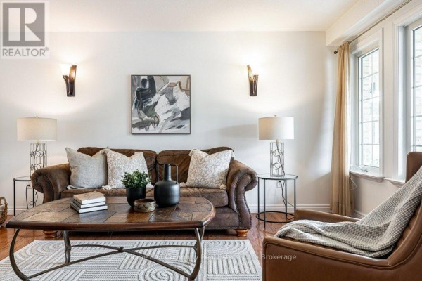 Living room with brown leather sofa, leather armchair, coffee table, and large windows with beige curtains. - 3 Lightbourne Avenue, Stratford