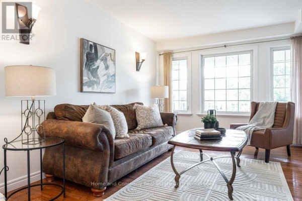 Living room showing a brown leather sofa, armchair, coffee table, and window view with beige curtains. - 3 Lightbourne Avenue, Stratford