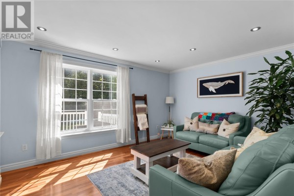 Living room with light blue walls, a large window, two sofas, and a coffee table. - 3 Maple Street, Conception Bay South
