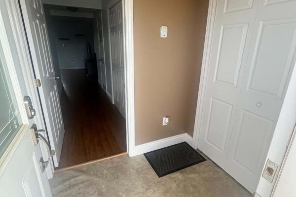 Interior entryway with beige walls, a black doormat, and a hallway leading to the left. - 3 Mcgregor Lane, Wabush